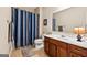 Bright bathroom features a single vanity with storage and a shower with a striped curtain at 6142 Golf View Xing, Locust Grove, GA 30248