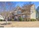 Charming two-story brick home featuring manicured lawn, multi-pane windows, and arched entry at 6142 Golf View Xing, Locust Grove, GA 30248