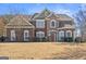 Charming two-story brick home featuring manicured lawn, multi-pane windows, and arched entry at 6142 Golf View Xing, Locust Grove, GA 30248