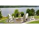 Outdoor firepit area with Adirondack chairs overlooking a serene lake at 6142 Golf View Xing, Locust Grove, GA 30248