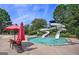 Community pool area featuring water slide, sun umbrellas, and lounge chairs at 6142 Golf View Xing, Locust Grove, GA 30248