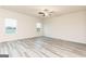 Light-filled living room with gray wood-look floors, bright white trim, and large windows providing natural light at 467 Prescott Way, Villa Rica, GA 30180