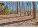 View of backyard with swing set, and deck overlooking the natural landscaping and trees at 562 Adams Rd, Fayetteville, GA 30214
