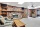 Basement featuring a large brick fireplace with a wooden mantel, and carpet floors at 562 Adams Rd, Fayetteville, GA 30214