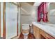 Bathroom with tiled floors and shower behind glass door, and wooden cabinets at 562 Adams Rd, Fayetteville, GA 30214