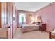 The cozy bedroom features soft pink walls, a comfortable bed, and natural light at 562 Adams Rd, Fayetteville, GA 30214