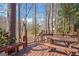 Wooden deck with a view of a lake, picnic table, and bench seating, surrounded by mature trees at 562 Adams Rd, Fayetteville, GA 30214