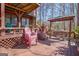 Wooden deck with plenty of outdoor seating including Adirondack chairs and benches, under a covered roof at 562 Adams Rd, Fayetteville, GA 30214