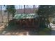 Exterior elevation of a cozy, two-story home featuring a covered front porch and surrounded by lush greenery and mature trees at 562 Adams Rd, Fayetteville, GA 30214
