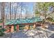 A three-car garage plus carport feature green roofs and wood-look facade and sit amid the trees on the property at 562 Adams Rd, Fayetteville, GA 30214