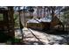 View of a two-car garage with a green roof and doors, plus a large parking pad, nestled in a wooded area at 562 Adams Rd, Fayetteville, GA 30214