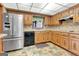 Cozy kitchen with wooden cabinets, stainless steel refrigerator, and stylish backsplash and flooring at 562 Adams Rd, Fayetteville, GA 30214