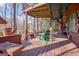 Large wooden patio with wooden benches and chairs, under a covered roof with an adjacent lake at 562 Adams Rd, Fayetteville, GA 30214