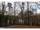 Secluded backyard with a meandering path leading to the lake through mature trees at 337 Lakeshore Dr, Berkeley Lake, GA 30096