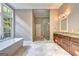 Modern bathroom featuring a soaking tub, glass shower, wood cabinets, and granite countertops at 337 Lakeshore Dr, Berkeley Lake, GA 30096