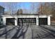 Exterior view of a three-car garage with modern black doors and stylish exterior lighting at 337 Lakeshore Dr, Berkeley Lake, GA 30096