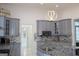 Modern kitchen with granite countertops, stainless appliances, stylish lighting, and gray cabinets at 337 Lakeshore Dr, Berkeley Lake, GA 30096