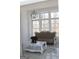 Elegant living room with large windows, tufted sofa, stylish lighting, and marble floors at 337 Lakeshore Dr, Berkeley Lake, GA 30096