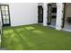Outdoor patio with artificial turf and view into living room at 337 Lakeshore Dr, Berkeley Lake, GA 30096