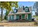 Exterior shot of a quaint two-story home with dormer windows and a covered front porch, offering curb appeal at 1444 Norman Berry Dr, East Point, GA 30344