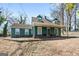 Inviting home with a covered front porch, featuring a classic design and mature trees on a sunny day at 1444 Norman Berry Dr, East Point, GA 30344