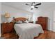 A spacious bedroom featuring hardwood floors, a ceiling fan, and classic wooden furniture at 555 Windchase Ln, Stone Mountain, GA 30083