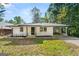 Charming white brick home featuring a covered carport and mature trees on a sunny day at 256 Butterworth Rd, Canton, GA 30114