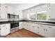 Bright kitchen with white cabinets, stainless steel appliances, and a window overlooking the backyard at 256 Butterworth Rd, Canton, GA 30114