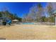 Backyard with pool and play set surrounded by lush greenery and trees at 140 Surrey Park Dr, Fayetteville, GA 30215