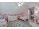 Pink attic bedroom featuring twin beds, dresser, ceiling fan, and carpeted floor at 140 Surrey Park Dr, Fayetteville, GA 30215