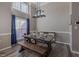 View of a well-lit dining area with rustic wood table, benches, and a modern hanging light fixture at 140 Surrey Park Dr, Fayetteville, GA 30215