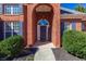 Inviting front entrance with an arched doorway and lush green shrubbery at 140 Surrey Park Dr, Fayetteville, GA 30215