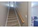 Carpeted staircase with wooden railing and a view of the upstairs room at 140 Surrey Park Dr, Fayetteville, GA 30215
