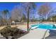 In-ground pool with diving board surrounded by concrete, features a well-kept garden area at 140 Surrey Park Dr, Fayetteville, GA 30215