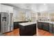 Well-equipped kitchen with a stainless steel refrigerator, white cabinets, and a center island at 1202 Persimmon Way, Mcdonough, GA 30252