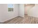 Bright bedroom featuring wood-look flooring and a large window, offering ample natural light at 8516 (Lot 130) Polston Place Dr, Douglasville, GA 30134