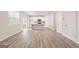 Open-concept kitchen with white cabinets, stainless appliances, and wood-look flooring at 8516 (Lot 130) Polston Place Dr, Douglasville, GA 30134