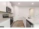 Well-equipped kitchen with stainless steel appliances, sleek granite counters, ample cabinet space, and modern finishes at 8516 (Lot 130) Polston Place Dr, Douglasville, GA 30134