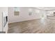 Open-concept living room with wood-look floors that flows into the modern kitchen at 8516 (Lot 130) Polston Place Dr, Douglasville, GA 30134