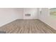 Spacious living room with wood-look flooring, a modern fireplace, and multiple windows at 8516 (Lot 130) Polston Place Dr, Douglasville, GA 30134