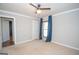 Bedroom featuring neutral walls, carpeted floors, a window with blue curtains and paneled doors at 100 Lanyard Bnd, Peachtree City, GA 30269