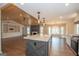 Gourmet kitchen features a large island, pendant lighting, and is adjacent to a fireplace and open living area at 100 Lanyard Bnd, Peachtree City, GA 30269