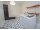 View of laundry room with cabinets, shelves, trendy flooring and modern washer and dryer at 100 Lanyard Bnd, Peachtree City, GA 30269