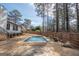 Backyard view of in-ground pool surrounded by stone pavers, fencing, mature trees and landscaping at 100 Lanyard Bnd, Peachtree City, GA 30269