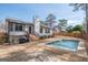 Backyard view of in-ground pool surrounded by stone pavers, and landscaping at 100 Lanyard Bnd, Peachtree City, GA 30269