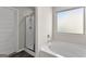 Bright bathroom with a tub under a window and a glass-enclosed shower stall at 1756 Beckworth Ln, Hampton, GA 30228
