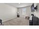 Bright bedroom with a wall-mounted TV, window with blinds, and neutral carpet at 1756 Beckworth Ln, Hampton, GA 30228