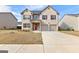 Charming two-story home featuring a brick facade, two-car garage, and well-manicured lawn at 1756 Beckworth Ln, Hampton, GA 30228