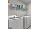 Laundry room with a modern washer and dryer, plus storage shelves at 1756 Beckworth Ln, Hampton, GA 30228