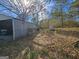 Backyard features a shed and detached garage surrounded by an abundance of fallen leaves at 4284 Highway 81 S, Covington, GA 30016